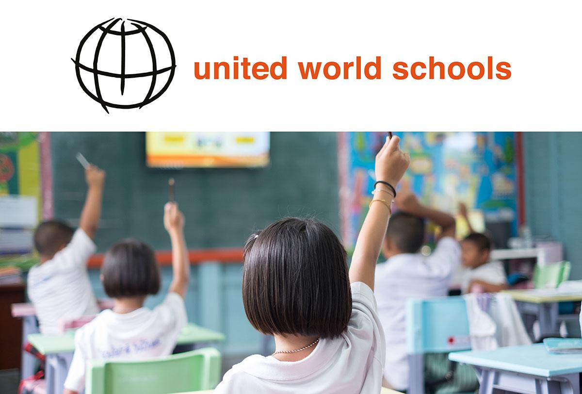 Barn i ett klassrum räcker upp handen med United World Schools logotyp