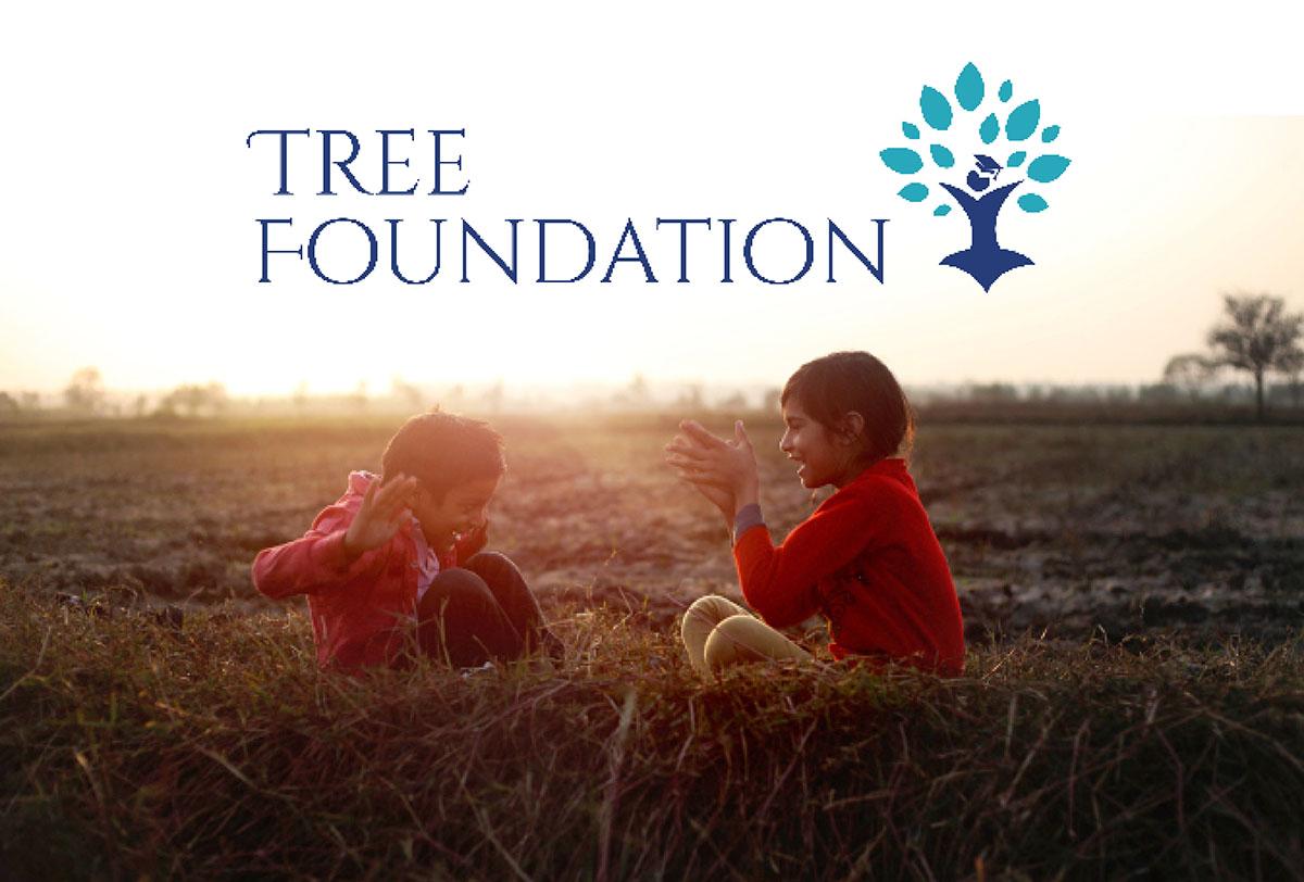 Två barn som leker på fälten med Tree Foundations logotyp