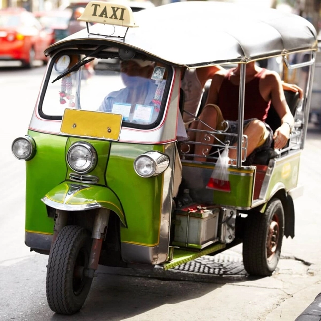 Ett trehjuligt fordon som transporterar ett par i Thailand