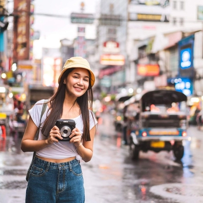 Asiatisk kvinna tar ett fotografi i stadsmiljö och visar sin kreativitet mitt i det urbana landskapet.