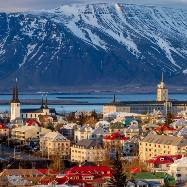 En isländsk stad omgiven av berg och vatten