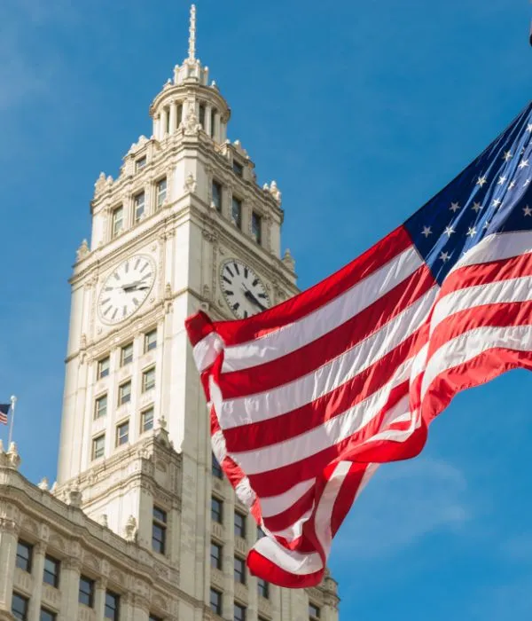 USA flag flying in front of skyscrapers 