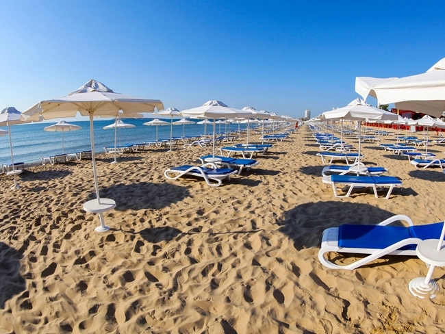 En strand i Bulgarien med solstolar och parasoller uppradade, redo att välkomna turister på semester