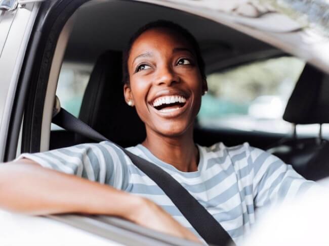 en kvinna som ler i en bil
